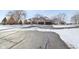 Exterior view of brick home with three-car garage, mature trees, and a snowy driveway at 6024 N County Road 50 W, Lizton, IN 46149