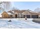 Exterior view of brick home with three-car garage, mature trees, and a snowy yard at 6024 N County Road 50 W, Lizton, IN 46149