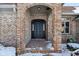 Close-up of brick home's front entrance featuring brick archway, black door, and snowy landscaping at 6024 N County Road 50 W, Lizton, IN 46149