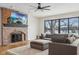 Comfortable living room featuring a brick fireplace, ceiling fan, and views of the snowy landscape at 6024 N County Road 50 W, Lizton, IN 46149