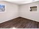 Cozy bedroom featuring wood-look floors, natural light from two windows, and neutral wall color at 639 S Alpha Ave, Brownsburg, IN 46112