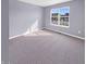 Sunlit bedroom features soft carpet, light gray walls, and a large window overlooking the neighborhood at 6812 W Wintergreen Ct, McCordsville, IN 46055