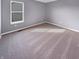 A cozy bedroom with neutral gray walls and plush carpeting, featuring a window that provides natural light at 6812 W Wintergreen Ct, McCordsville, IN 46055