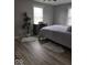 Cozy bedroom featuring modern gray walls, wood look floors and a variety of plants and storage at 7152 Old Morgantown Rd, Martinsville, IN 46151