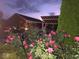 Exterior dusk shot of a brick home and gazebo with a flower garden in the foreground at 7152 Old Morgantown Rd, Martinsville, IN 46151