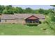 Charming brick home with a well-manicured lawn, inviting front porch, and a backdrop of lush trees at 7152 Old Morgantown Rd, Martinsville, IN 46151