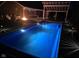 Evening view of the in-ground pool with landscape lighting and covered outdoor seating area at 7152 Old Morgantown Rd, Martinsville, IN 46151
