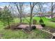 Lush backyard featuring green grass, mature trees, and a brick patio area at 7344 Monon Cir, Indianapolis, IN 46256