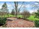 Cozy brick patio nestled in a lush backyard setting offers a serene outdoor living space and beautiful natural surroundings at 7344 Monon Cir, Indianapolis, IN 46256