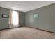 Spacious empty room with plush carpet, neutral paint, and natural light from large windows at 7344 Monon Cir, Indianapolis, IN 46256