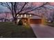 Charming two-story home featuring a brick facade, attached two-car garage, and landscaped front yard at dusk at 7344 Monon Cir, Indianapolis, IN 46256