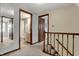 Bright hallway featuring neutral tones, a wooden staircase, and access to a bathroom at 7344 Monon Cir, Indianapolis, IN 46256