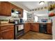 Spacious kitchen with wood cabinets, black appliances, wood-look flooring and plenty of storage at 7344 Monon Cir, Indianapolis, IN 46256