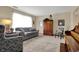 Bright living room with a gray sofa, accent chair, and natural light streaming through the large window at 7344 Monon Cir, Indianapolis, IN 46256