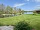 Expansive backyard overlooking a tranquil lake with a fountain and lush greenery, creating a peaceful retreat at 7357 Windridge Way, Brownsburg, IN 46112