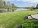 Lush backyard with manicured lawn, a serene pond, and mature trees, offering a picturesque view at 7357 Windridge Way, Brownsburg, IN 46112