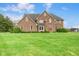 Stately brick home with a well-manicured lawn, mature trees, and an inviting front entrance at 7357 Windridge Way, Brownsburg, IN 46112