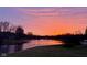 Dramatic lake view featuring a vibrant pink sunset and a tranquil shoreline at 7357 Windridge Way, Brownsburg, IN 46112