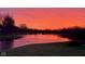 Beautiful lake view at sunset with tranquil water, surrounding trees, and a sky full of pink clouds at 7357 Windridge Way, Brownsburg, IN 46112