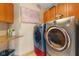 Modern laundry room showcasing a washer and dryer set with overhead cabinets for storage at 7357 Windridge Way, Brownsburg, IN 46112