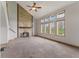 Living room features a stone fireplace, large windows, and neutral carpet at 7357 Windridge Way, Brownsburg, IN 46112