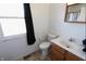 Bright bathroom with a single sink vanity, toilet, and window bringing in natural light at 7438 Melanie Ln # 13, Indianapolis, IN 46217