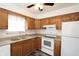 Well-lit kitchen featuring wooden cabinets, a white oven, and laminate countertops, offering a functional cooking space at 7438 Melanie Ln # 13, Indianapolis, IN 46217
