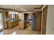 Bright kitchen features stainless steel refrigerator, granite countertops, wood cabinets and an island with cooktop at 7474 Oakland Hills Dr, Indianapolis, IN 46236