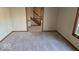 Bright living area with carpet flooring and a view of the staircase at 7474 Oakland Hills Dr, Indianapolis, IN 46236