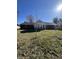 View of the backyard, featuring a mix of lawn, mature trees, and the house exterior at 7632 S Sherman Dr, Indianapolis, IN 46237