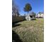 Backyard featuring a shed, mature trees, lawn and view of neighboring houses at 7632 S Sherman Dr, Indianapolis, IN 46237