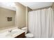 Functional bathroom with a single sink vanity, toilet, and shower featuring a clean white curtain at 7710 Eagle Crescent Dr, Zionsville, IN 46077