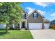 Traditional two-story home with a well-manicured lawn and a three-car garage at 7710 Eagle Crescent Dr, Zionsville, IN 46077