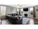 Spacious living room with hardwood floors, neutral paint, a ceiling fan, a fireplace, and a large leather couch at 7710 Eagle Crescent Dr, Zionsville, IN 46077