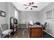 Well-lit home office features hardwood floors, a ceiling fan, a large desk, and a view of the neighborhood at 7710 Eagle Crescent Dr, Zionsville, IN 46077