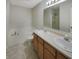 Well-lit bathroom with a double sink vanity, soaking tub, and tiled floors at 825 Treyburn Green Dr, Indianapolis, IN 46239