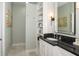 Bathroom featuring a granite vanity top, decorative mirror and wall-mounted lighting fixtures at 1014 Jackson St, Columbus, IN 47201