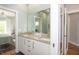 Bathroom featuring dual sinks, granite countertop, white cabinets and a large mirror at 1014 Jackson St, Columbus, IN 47201