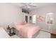 Bright bedroom with a cozy bed, a ceiling fan, and views from two windows at 1014 Jackson St, Columbus, IN 47201
