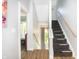 Hallway with wood floors and staircase with black carpet and white risers at 1014 Jackson St, Columbus, IN 47201