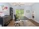 Bright home office featuring a ceiling fan, a balcony overlooking lush greenery, and stylish decor elements at 1014 Jackson St, Columbus, IN 47201