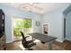 This home office is equipped with a ceiling fan, modern desk, and sliding door to a balcony with an outdoor seating area at 1014 Jackson St, Columbus, IN 47201