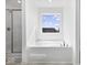 Modern bathtub with large window, and glass door shower provides ample space at 1033 Fuller Ln, Shelbyville, IN 46176