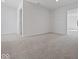 Large bedroom with neutral carpet and white walls, connected to another room through an open doorway at 1033 Fuller Ln, Shelbyville, IN 46176