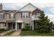 Charming townhouse with tan siding, brick accents, green trim, a small balcony, and a well-manicured lawn at 12145 Bubbling Brook Dr # 600, Fishers, IN 46038