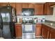 Well-lit kitchen features stainless steel appliances and wooden cabinetry at 12145 Bubbling Brook Dr # 600, Fishers, IN 46038