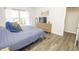 Well-lit main bedroom with wood-look floors, a full dresser, and a comfortable bed at 12145 Bubbling Brook Dr # 600, Fishers, IN 46038