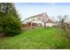 Spacious backyard featuring a wooden deck, lush green grass, and a lovely blossoming tree at 12512 Geist Cove Dr, Indianapolis, IN 46236