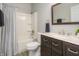 Bathroom with white shower-tub combo, dark vanity with marble counter, and framed mirror at 12512 Geist Cove Dr, Indianapolis, IN 46236