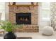 Close-up view of the brick fireplace with a wooden mantle and decorative accents in the living room at 12512 Geist Cove Dr, Indianapolis, IN 46236
